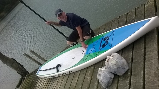 Peter with his paddle board and some of the rubbish he collected in Latham Bay